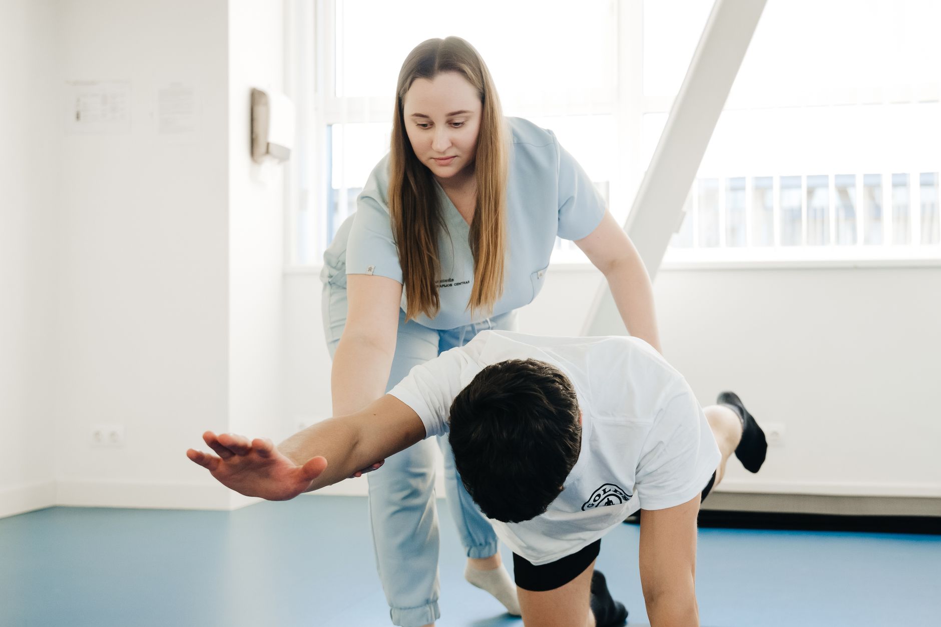 Practitioner guiding a patient through a movement assessment and stretching exercise