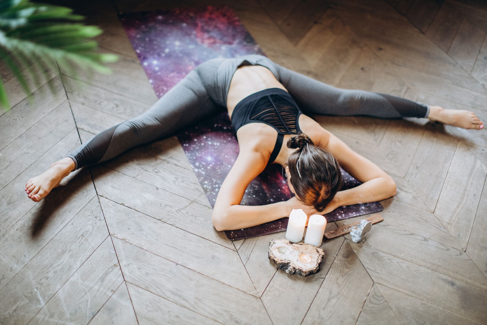 Woman in a restorative yin yoga pose with candles, promoting relaxation