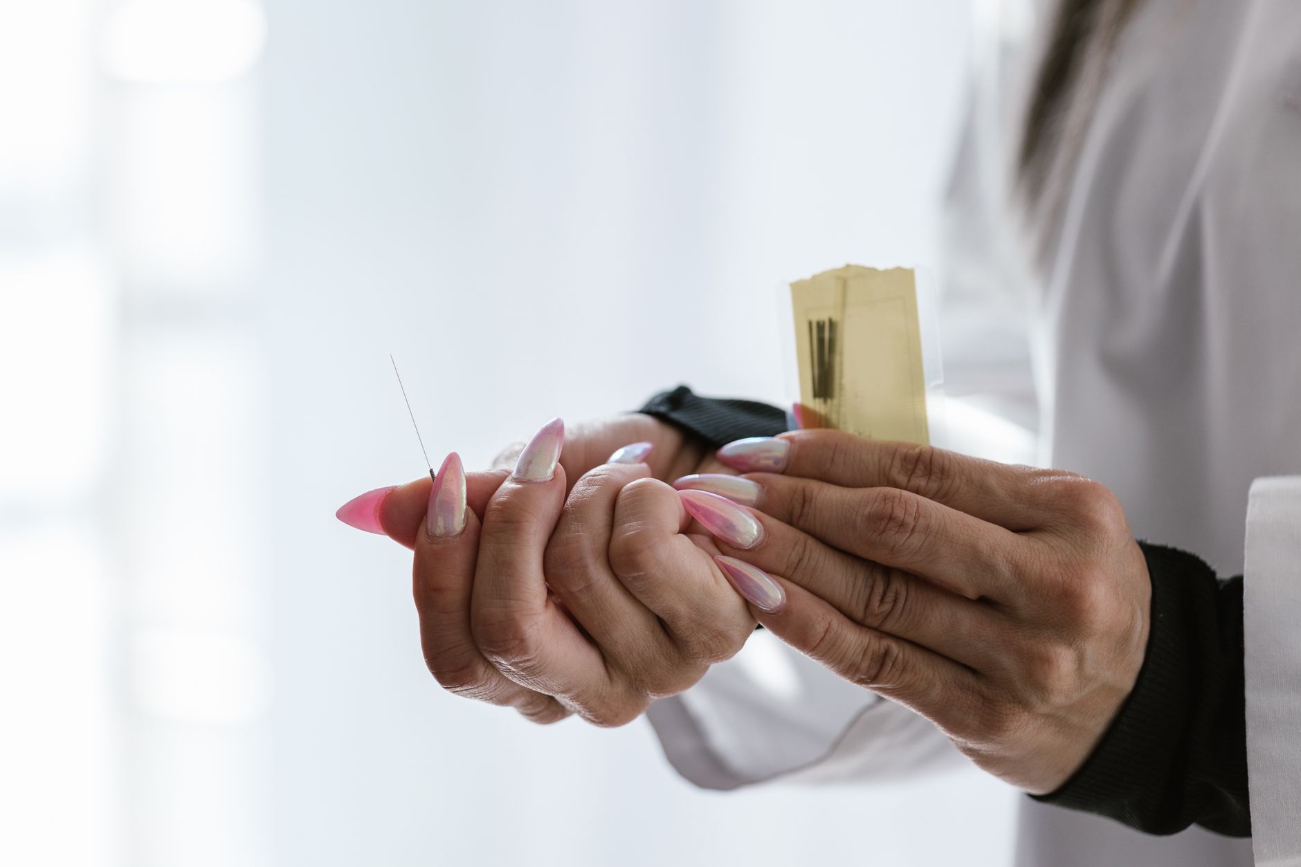 Close-up of an acupuncturist's hands holding specialized needles
