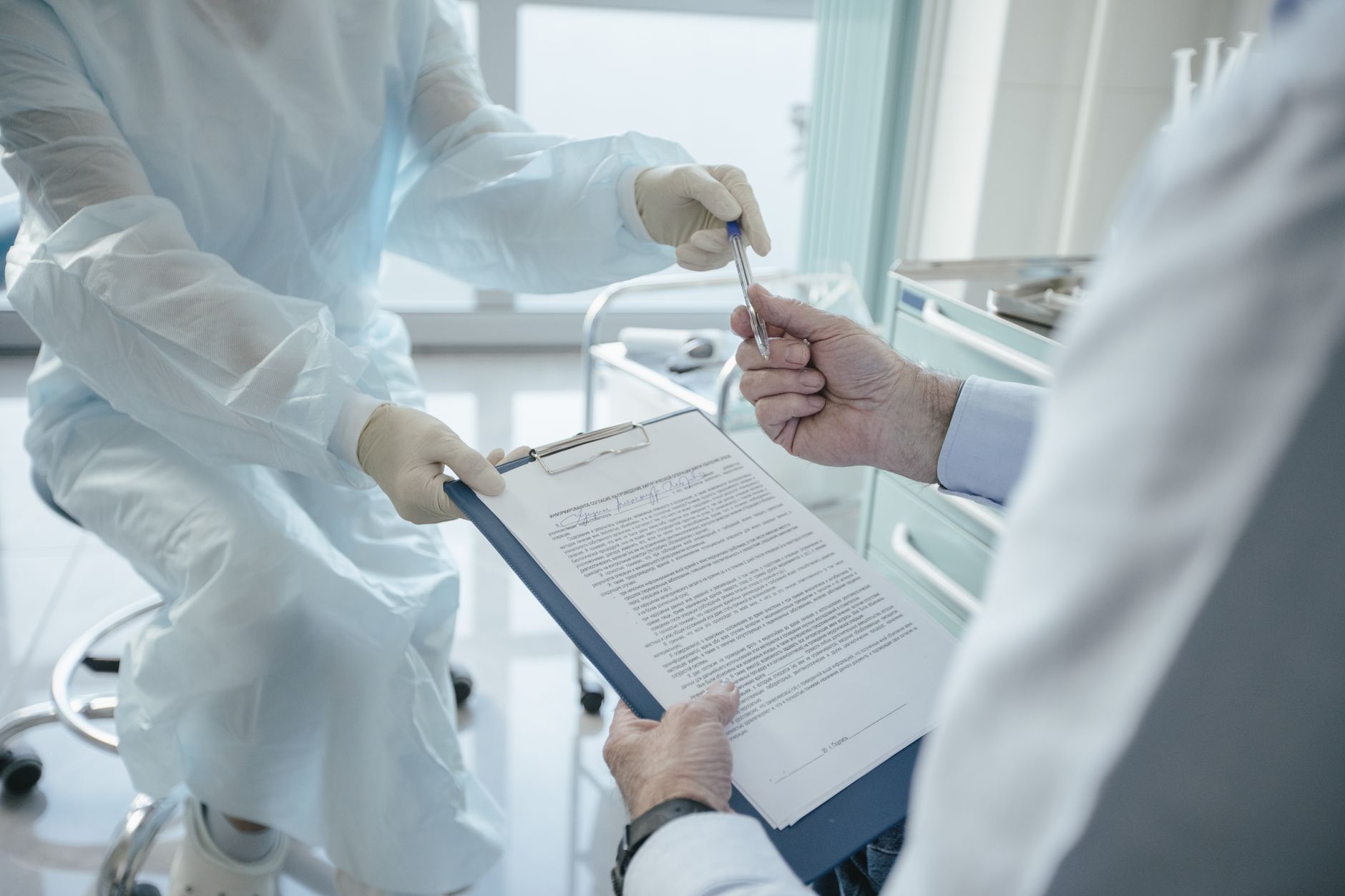 Practitioner handing insurance paperwork to a patient